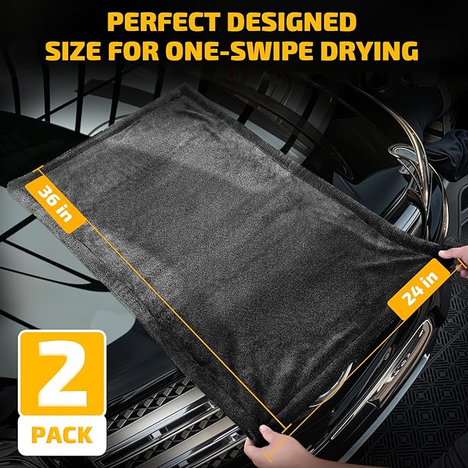 Extra large 24x36 inch car drying towel. Perfect designed size for one-swipe drying, showing hands spreading the 2-pack premium grey microfiber towels on car hood.